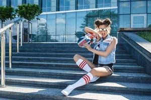 menina elegante com um skate na rua foto