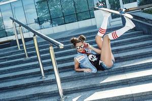 menina elegante com um skate na rua foto