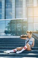 menina elegante com um skate na rua foto