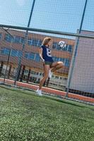 linda garota com bola no campo de futebol foto