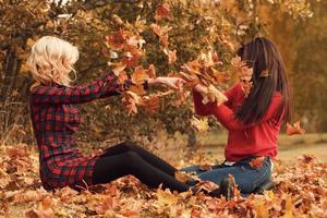 duas amigas lindas se divertindo no parque outono foto