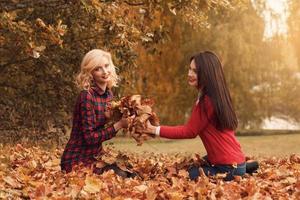 duas amigas lindas se divertindo no parque outono foto