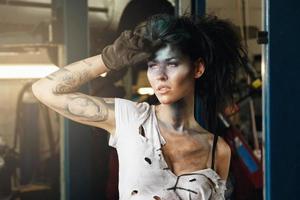 mulher mecânica na garagem com maquiagem artística no rosto estilizado como uma mancha suja foto