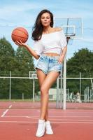jovem mulher sexy com um playground de basquete foto