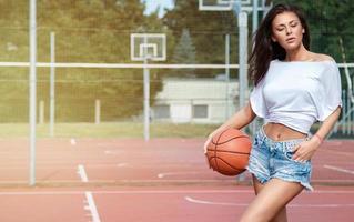 jovem mulher sexy com um playground de basquete foto