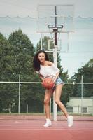 jovem mulher sexy com um playground de basquete foto