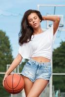 jovem mulher sexy com um playground de basquete foto