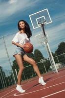 jovem mulher sexy com um playground de basquete foto