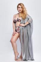 linda modelo plus size vestindo lingerie e peça de tecido foto