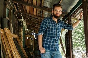 bonito jovem barbudo em camisa quadriculada foto