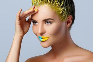 mulher bonita com cabelo amarelo e unhas e lábios coloridos foto