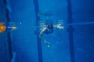 mulher nadadora debaixo d'água durante seu treino na piscina foto