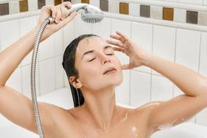 mulher lavando o cabelo no chuveiro no banheiro foto