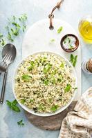 arroz de couve-flor com ervas e suco de limão em uma tigela branca foto