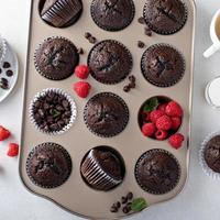 muffins de chocolate em uma forma de muffin com framboesas foto