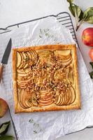 tarte de maçã com massa folhada coberta com nozes e açúcar mascavado foto