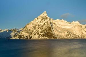 cabana de pesca no pico da montanha hamnoy e lilandstinden no inverno em reine, ilhas lofoten, noruega. foto