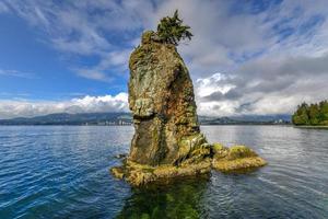 siwash rock, também conhecido pelo nome squamish skaish, uma famosa formação rochosa no paredão do parque stanley vancouver columbia britânica canadá foto