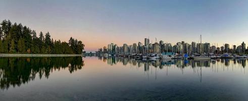 horizonte do centro de vancouver ao entardecer de stanley park, canadá. foto