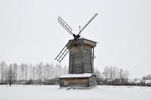 o moinho de vento de madeira no museu de arquitetura de madeira e vida dos camponeses em um dia de inverno em suzdal, rússia. foto