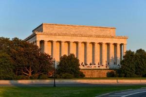 washington, dc - 3 de abril de 2021 - lincoln memorial por trás com espectadores apreciando o pôr do sol na primavera em washington, dc foto