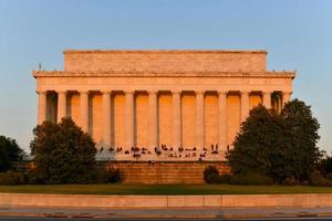 washington, dc - 3 de abril de 2021 - lincoln memorial por trás com espectadores apreciando o pôr do sol na primavera em washington, dc foto