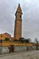 o campanário inclinado da igreja de san martino, na ilha de burano, é uma igreja católica romana do século xvi em veneza, itália. foto