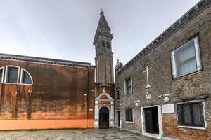 o campanário inclinado da igreja de san martino, na ilha de burano, é uma igreja católica romana do século xvi em veneza, itália. foto