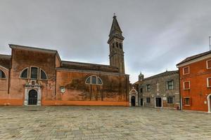 o campanário inclinado da igreja de san martino, na ilha de burano, é uma igreja católica romana do século xvi em veneza, itália. foto