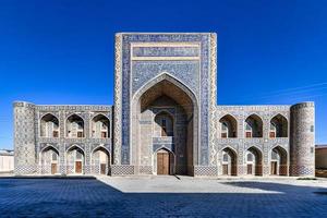 o abdullah khan madrassah ostenta o pátio perfeitamente decorado com rendilhados de azulejos azuis nas paredes em bucara, uzbequistão. foto