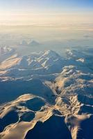 uma vista aérea das montanhas cobertas de neve dos fiordes da noruega no inverno. foto