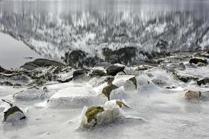 rocha rachando no gelo em vagspollen nas ilhas lofoten, noruega no inverno. foto