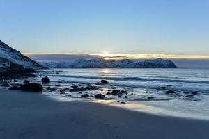 praia de vikten nas ilhas lofoten, noruega no inverno ao pôr do sol. foto