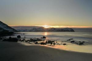praia de vikten nas ilhas lofoten, noruega no inverno ao pôr do sol. foto