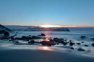 praia de vikten nas ilhas lofoten, noruega no inverno ao pôr do sol. foto