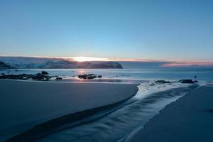 praia de vikten nas ilhas lofoten, noruega no inverno ao pôr do sol. foto