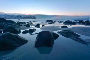 praia de vikten nas ilhas lofoten, noruega no inverno ao pôr do sol. foto