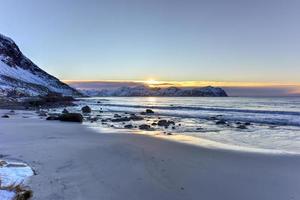 praia de vikten nas ilhas lofoten, noruega no inverno ao pôr do sol. foto