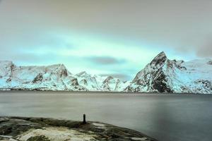 cabana de pesca no pico da montanha hamnoy e lilandstinden no inverno em reine, ilhas lofoten, noruega. foto