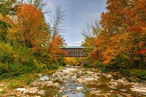 ponte coberta de grist mill em cambridge, vermont, durante a folhagem de outono. foto