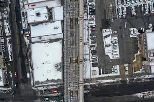 vista aérea de um trem cruzando trilhos elevados cobertos de neve que se estendem de coney island, brooklyn, nova york. foto