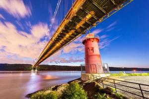 ponte george washington e o pequeno farol vermelho em fort washington park, nova york, ny à noite. foto