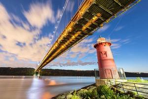 ponte george washington e o pequeno farol vermelho em fort washington park, nova york, ny à noite. foto