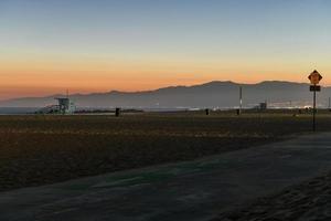 pôr do sol em venice beach, califórnia, enquanto o sol se põe atrás das montanhas. foto