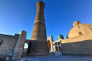 grande minarete do kalon em bucara, uzbequistão. é um minarete do complexo da mesquita po-i-kalyan em bucara, uzbequistão e um dos marcos mais proeminentes da cidade. foto