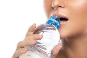 boca e garrafa de água no fundo branco foto