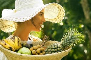linda mulher usando chapéu de aba larga no jardim tropical foto