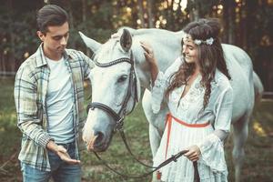 jovem casal cuidando de belo cavalo foto