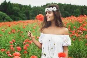 mulher bonita no campo com muitas flores de papoula foto