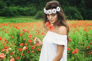 mulher bonita no campo com muitas flores de papoula foto